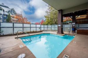 a large swimming pool with blue water at 1BR Stylish Condo central Village Location with Private Balcony in Whistler