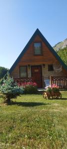 a house with a yard with flowers and a house at Bungalov Veruša in Podgorica