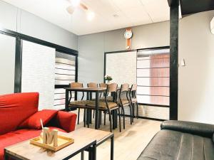 a living room with a red couch and a table at Marutoku House Wakayama A - Vacation STAY 16947 in Wakayama