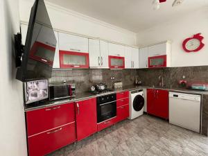 a red and white kitchen with red cabinets at Tahir home in Bilgah