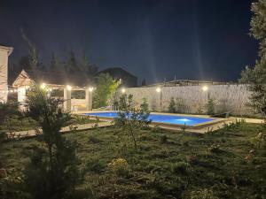 a house with a swimming pool at night at Tahir home in Bilgah