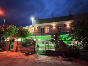 a building with green lights on it at night at Hotel Villa Flowers 2 in Vlorë