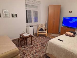 una camera con 2 letti, una TV e una sedia di Rahat Apartment a Sarajevo Altre 23 foto