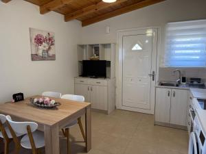 a kitchen with a table and chairs and a kitchen with a sink at The Wooden Nest in Asgourou