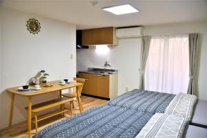 ein Schlafzimmer mit Bett und Tisch und eine Küche in der Unterkunft Kyoto Yuyado Fushimi Inari - Vacation STAY 95187v in Kyoto