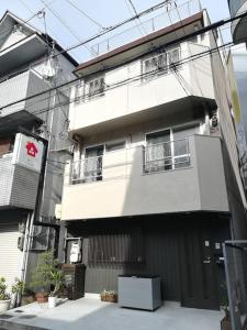 a large white building with windows and a fence at Kyoto Yuyado Fushimi Inari - Vacation STAY 95208v in Kyoto