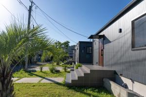 una casa con una escalera al lado de un edificio en LOCALINO STAY AOSHIMA - Vacation STAY 17893, en Miyazaki