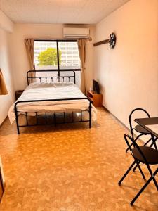 a bedroom with a bed and a table and chairs at Hare no hi Hakushima - Vacation STAY 94984v in Hiroshima