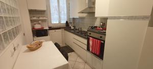a white kitchen with a table and a stove at Mura di prati in Rome +18 photos