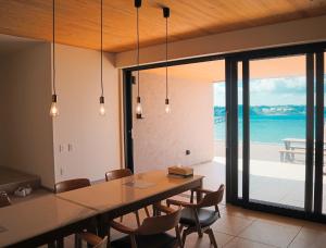 a dining room with a table and chairs and the ocean at Villa Mikuri Tsunoshima - Vacation STAY 02176v in Shimonoseki