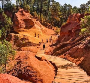 a group of people walking on a wooden path in a canyon at L' Escale in Bonnieux