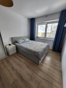 a bedroom with a bed and two windows at Apartamenty Modrzewiowa Enklawa in Debina