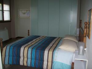 Dormitorio pequeño con cama con manta a rayas en La Bottega Del Falegname, en Vanzaghello