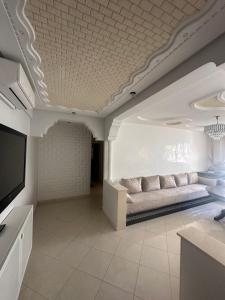 een woonkamer met een bank en een tv bij Bayti Appart in Agadir