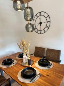 a dining room table with a clock on the wall at Royal Haus Soltau in Soltau +8 photos