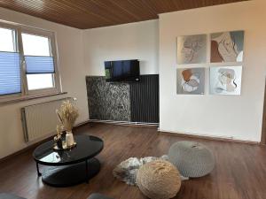 a living room with a table and a tv at Royal Haus Soltau in Soltau