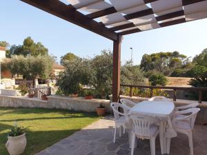 une table blanche et des chaises sur une terrasse dans l'établissement Villa Corallo, à Porto Carollo