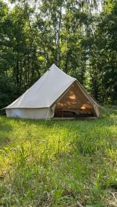 a tent sitting in the grass in a field at Glamping Stodoła Tent in Ściegny