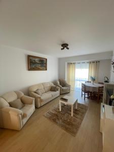 een woonkamer met twee banken en een tafel bij Refúgio do Mar - Peniche in Peniche