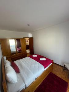 een slaapkamer met een groot bed met rode en witte kussens bij Refúgio do Mar - Peniche in Peniche