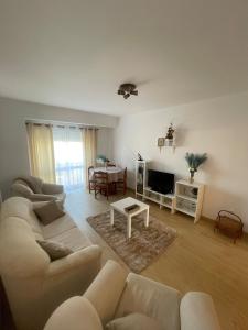 een woonkamer met een bank en een tafel bij Refúgio do Mar - Peniche in Peniche