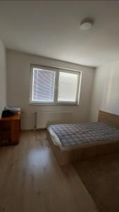 a bedroom with a bed and two windows at 2BR apartment in Fushe Kosova in Kosovo Polje