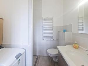 a white bathroom with a toilet and a sink at Bel Appart 10 min de Paris et Orly in Juvisy-sur-Orge