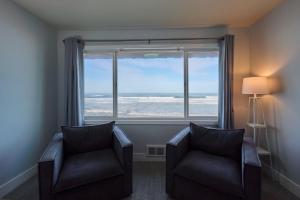 a room with two chairs and a large window at Oceanfront Suite - Upper Floor in Lincoln City +26 photos