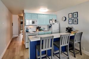 a kitchen with blue cabinets and a counter with chairs at Oceanfront Suite - Upper Floor in Lincoln City