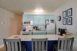 a kitchen with blue cabinets and a white refrigerator at Oceanfront Suite - Upper Floor in Lincoln City