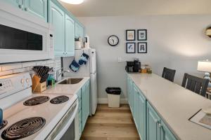 a kitchen with blue cabinets and a white refrigerator at Oceanfront Suite - Upper Floor in Lincoln City