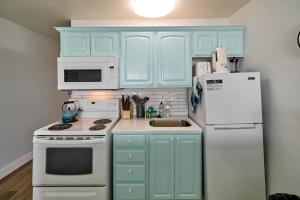 a kitchen with blue cabinets and a white refrigerator at Oceanfront Suite - Upper Floor in Lincoln City