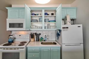 a kitchen with blue cabinets and a white refrigerator at Oceanfront Suite - Upper Floor in Lincoln City +26 photos