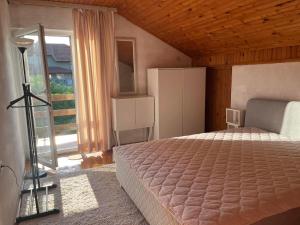 a bedroom with a bed and a large window at Apartman Vana in Vrnjačka Banja