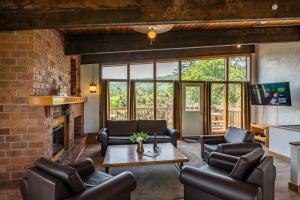 a living room with leather furniture and a brick wall at 6 bdrm Cottage at Blue Mountain, Private Beach Access, Hot Tub, Sauna, BBQ, Petfriendly in Blue Mountains