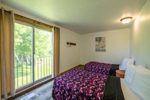 a bedroom with a bed and a large window at 6 bdrm Cottage at Blue Mountain, Private Beach Access, Hot Tub, Sauna, BBQ, Petfriendly in Blue Mountains +17 photos