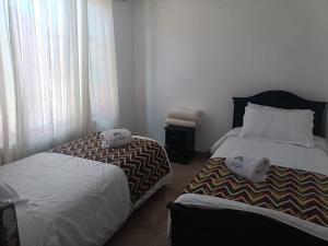 two beds sitting next to each other in a bedroom at Casa Campestre Arama in Paipa