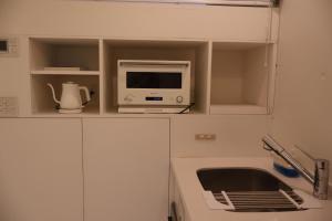 una cucina con forno a microonde e un computer su un bancone di Loisir Tateyama - Vacation STAY 11049v a Tateyama Altre 5 foto