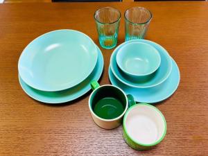 a table with plates and cups on a wooden table at Ohana Inn - Vacation STAY 10994v in Kuka +15 photos