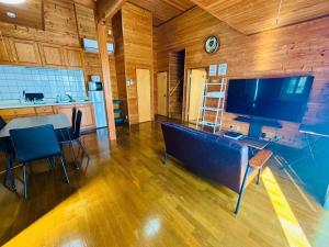 a living room with a large television and a table and chairs at Ohana Inn - Vacation STAY 10994v in Kuka