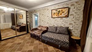 a living room with a couch and a chair at 2 bedroom apartment metro Vasilkovskaya in Kyiv