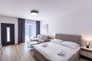 a bedroom with a large bed and a couch at Villa Cherry in Rogoznica