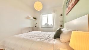 a white bedroom with a bed and a window at Edna 2 in Funchal