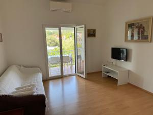 a living room with a couch and a television at Apartments Biserka in Palit