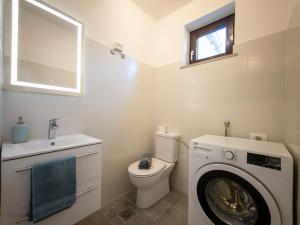 a bathroom with a toilet and a washing machine at Apartma Flora - Apartment Flora in Koper