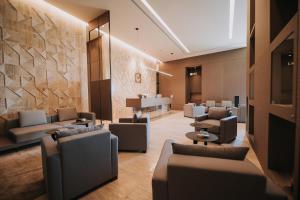 a waiting room with couches and chairs in a lobby at Magnus Hotel & SPA in Vlorë