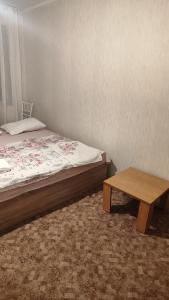 Un dormitorio con una cama y una mesa de madera. en Апартамент Колев Ретро, en Varna