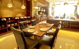 a dining room with a wooden table and chairs at Grand Serela Yogyakarta by KAGUM Hotels in Yogyakarta