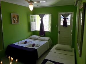 a green bedroom with two beds and a window at Hotel Pousada Papaya Verde in Salvador