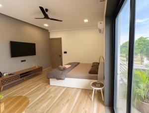 a bedroom with a bed and a flat screen tv at Skywood Villa Rooms in Lucknow